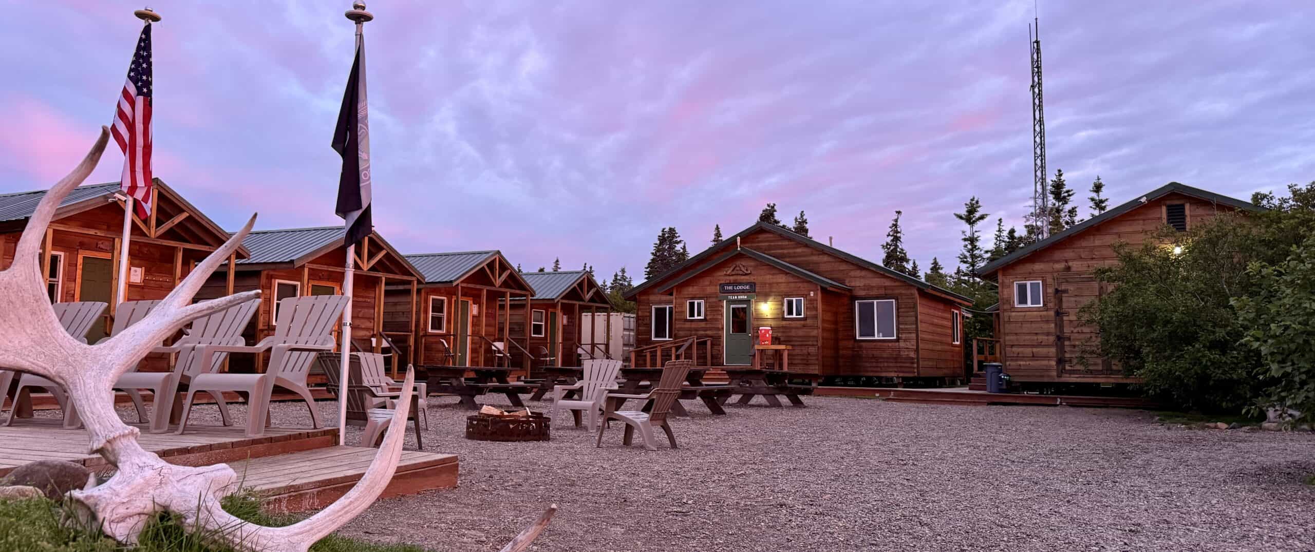 Rustic cabins with flag sunset.
