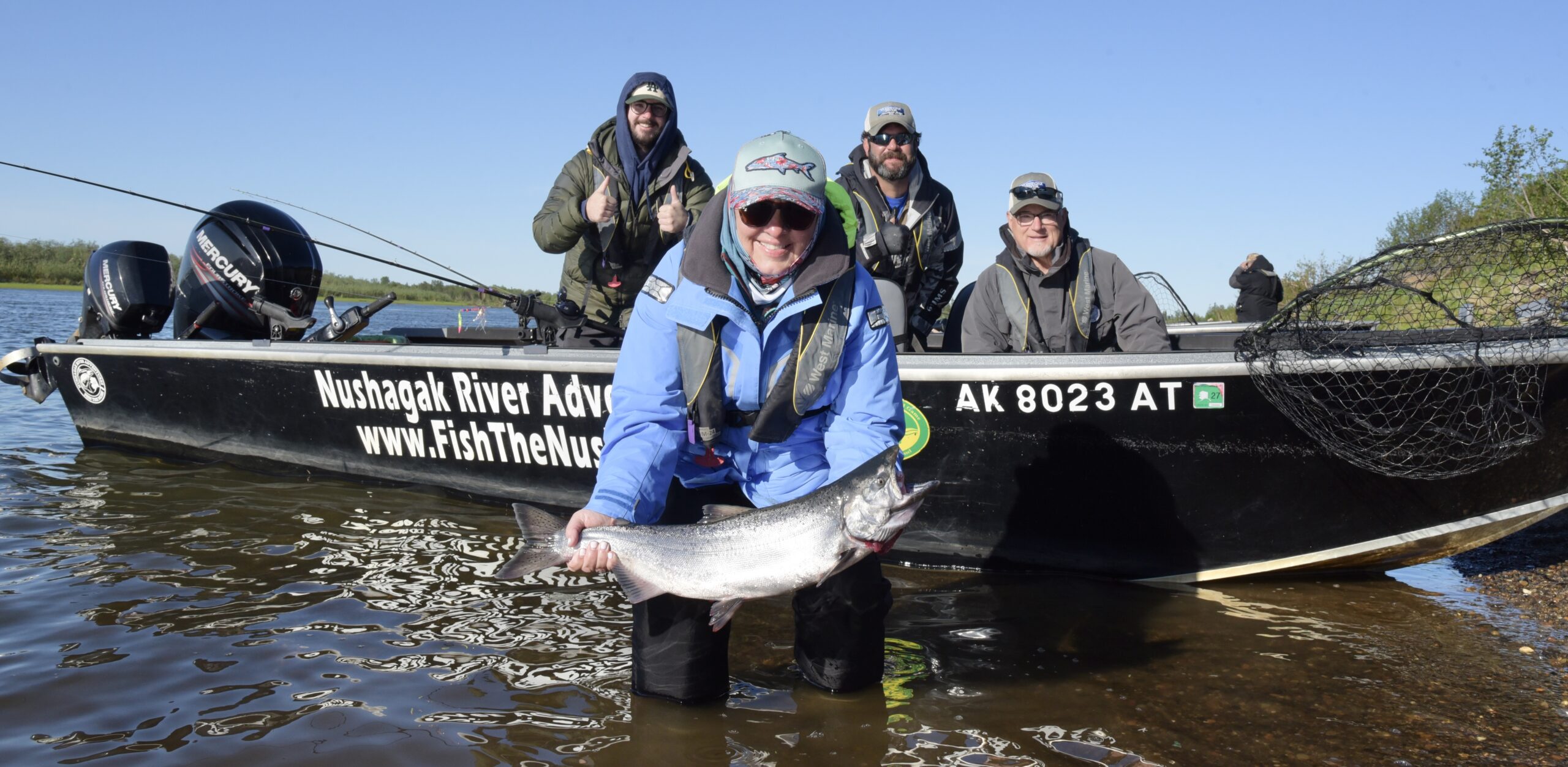 Angler holding a Nushagak River salmon beside the boat before release