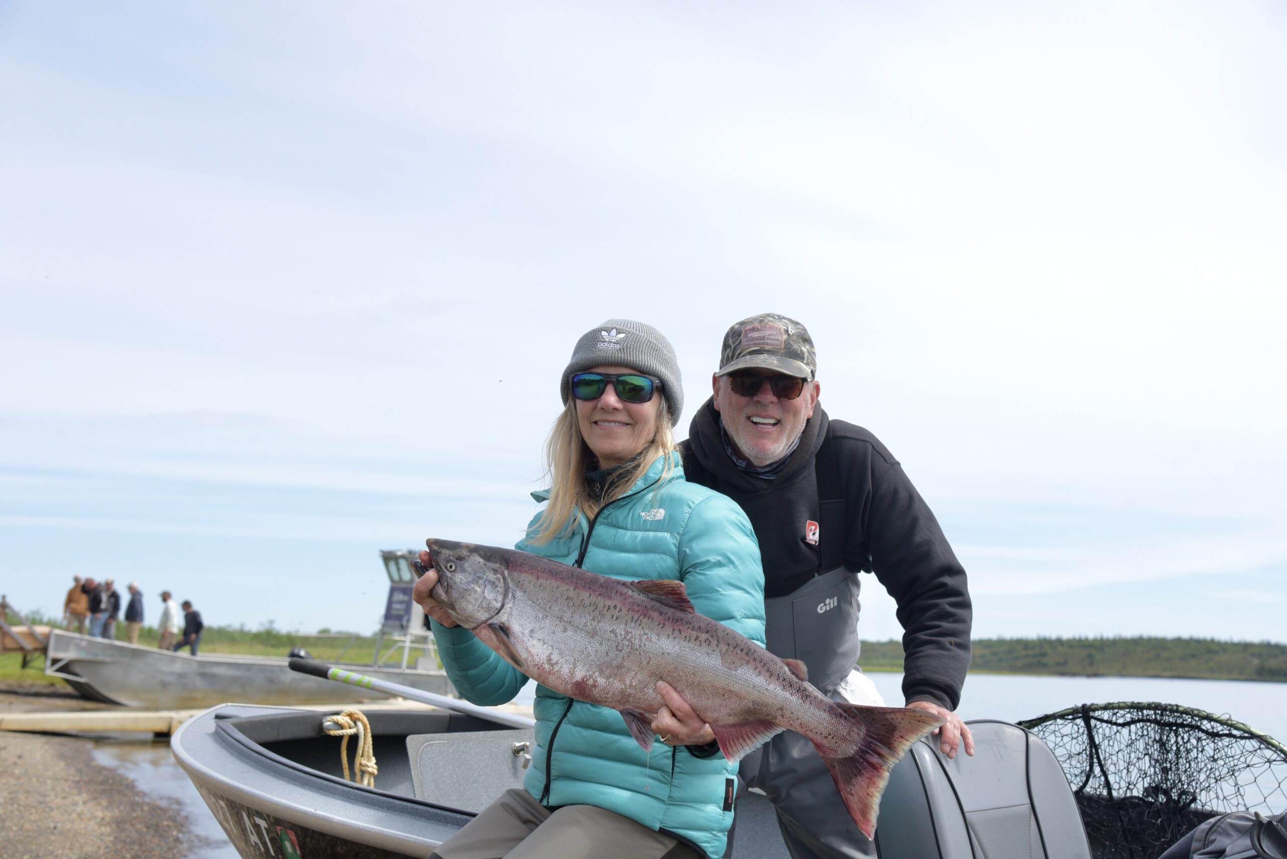 Guests aboard a Fish The Nush boat with a Nushagak River salmon