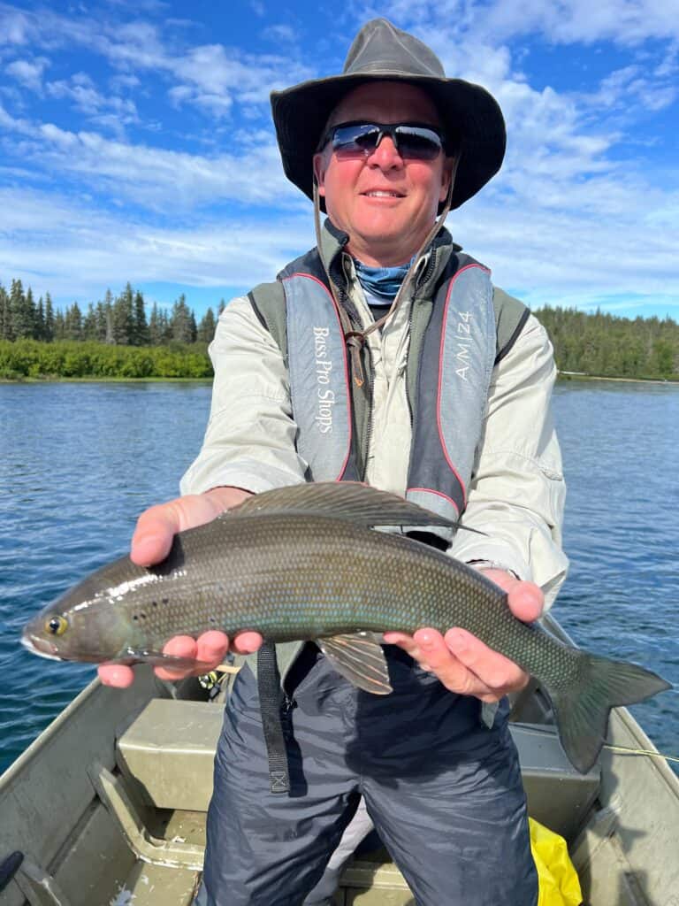 Man holds fish in boat